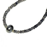 Bracelet with gray beads and a gold clasp on a white background